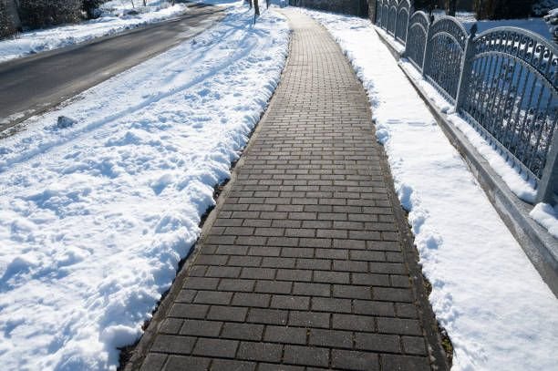 Cleared and salted walkway lit at night in Rochester NY